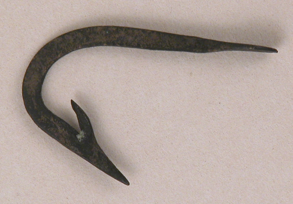 An old iron fish hook on a plain background